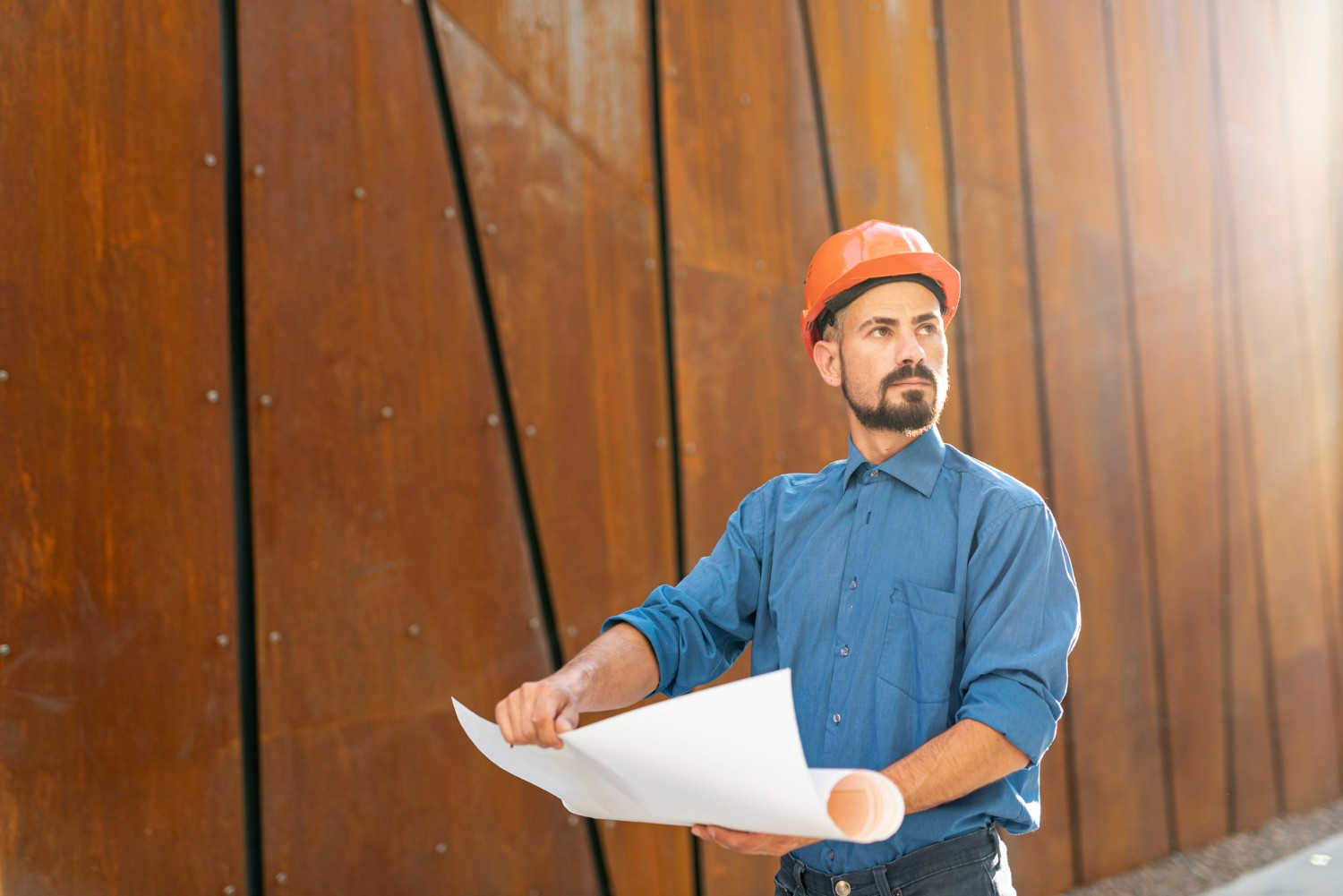 Profissional segurando planta de projeto de construção
