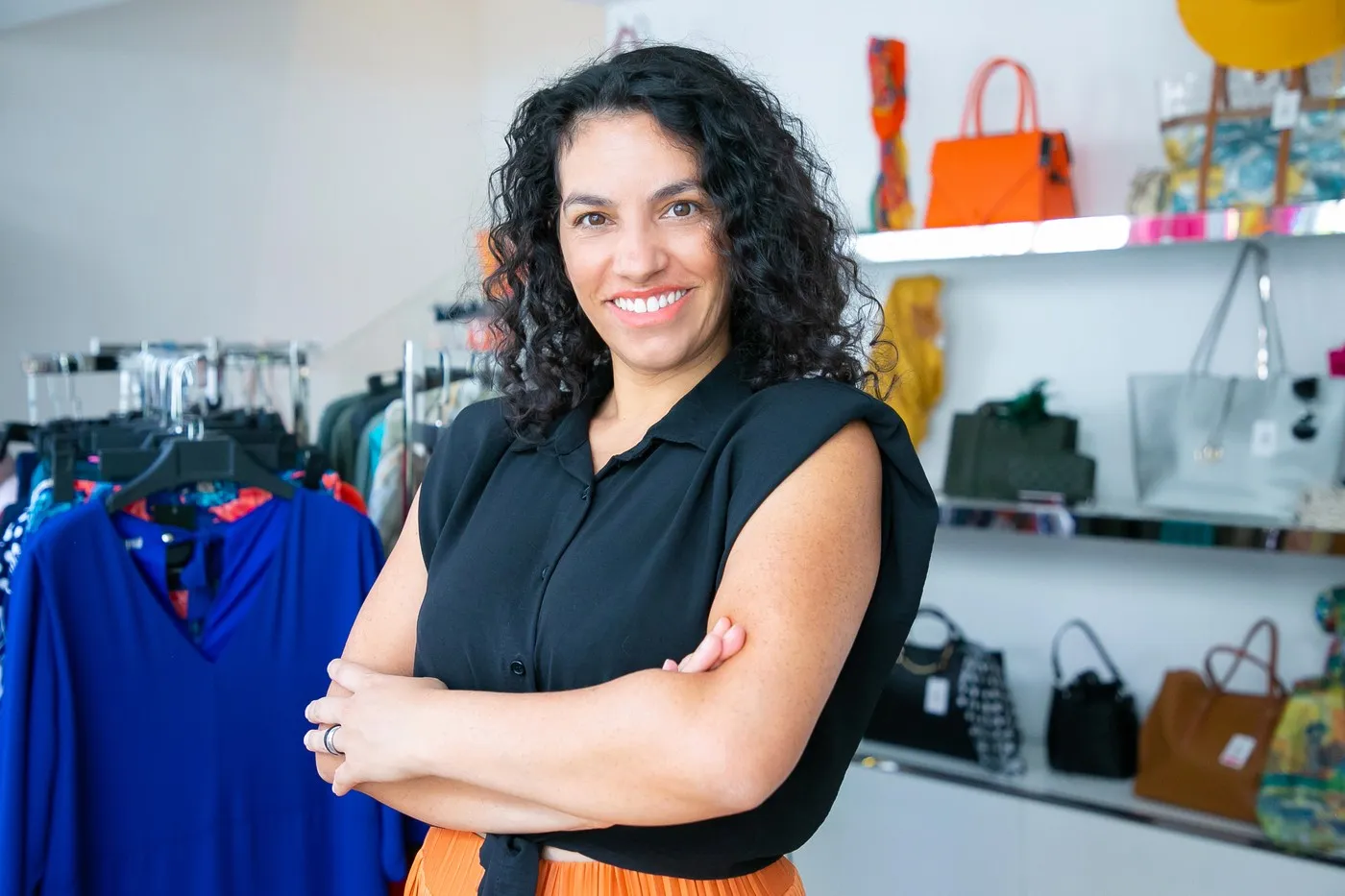 Empreendedora em loja de roupas representando pequena empresa enquadrada no Simples Nacional, após escolha correta do CNAE.