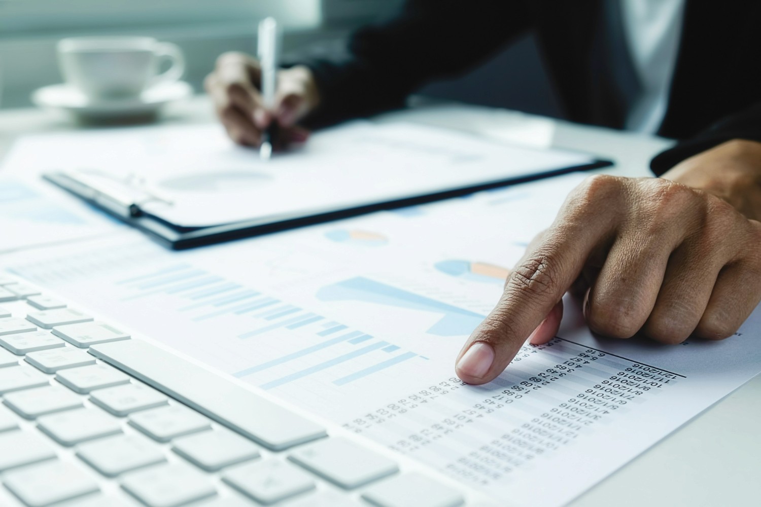 Profissional analisando planilhas e gráficos financeiros sobre a mesa