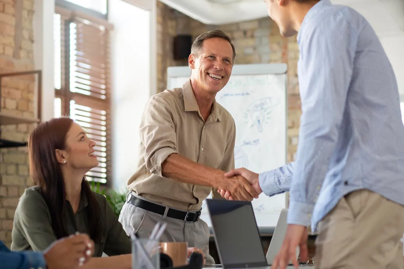 Gestores públicos e empreendedores cumprimentando-se em uma reunião – conceito de parceria e fortalecimento do ambiente de negócios.