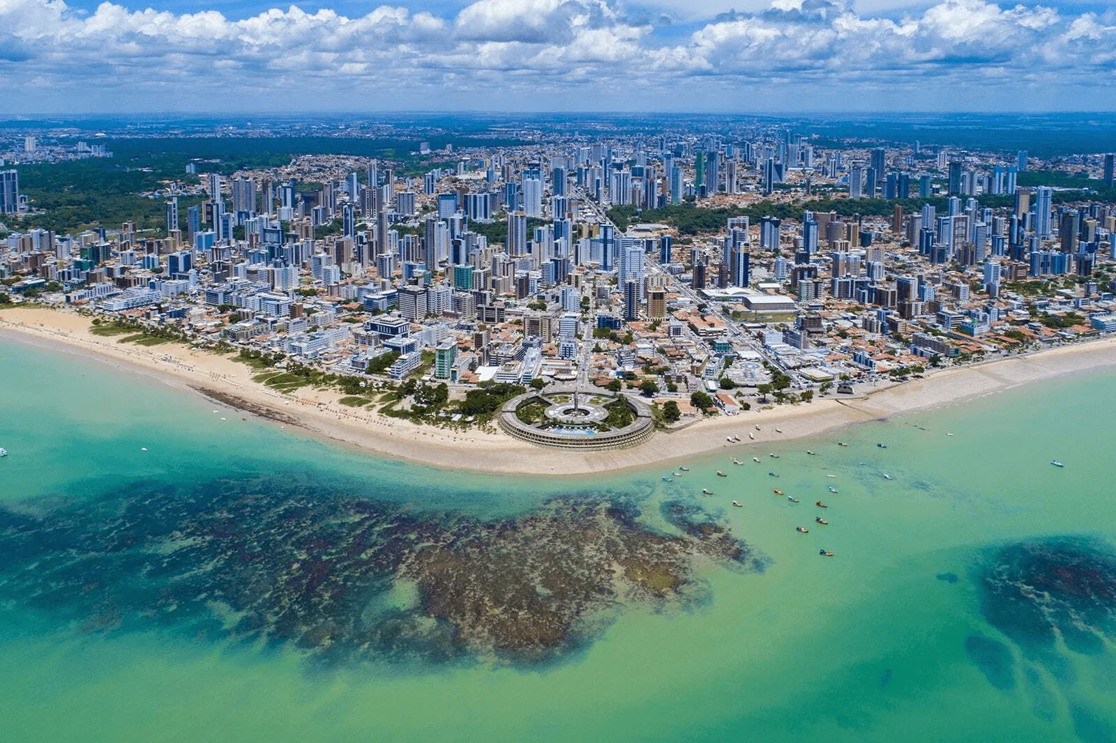 Servidores públicos sorrindo em frente a um prédio da prefeitura