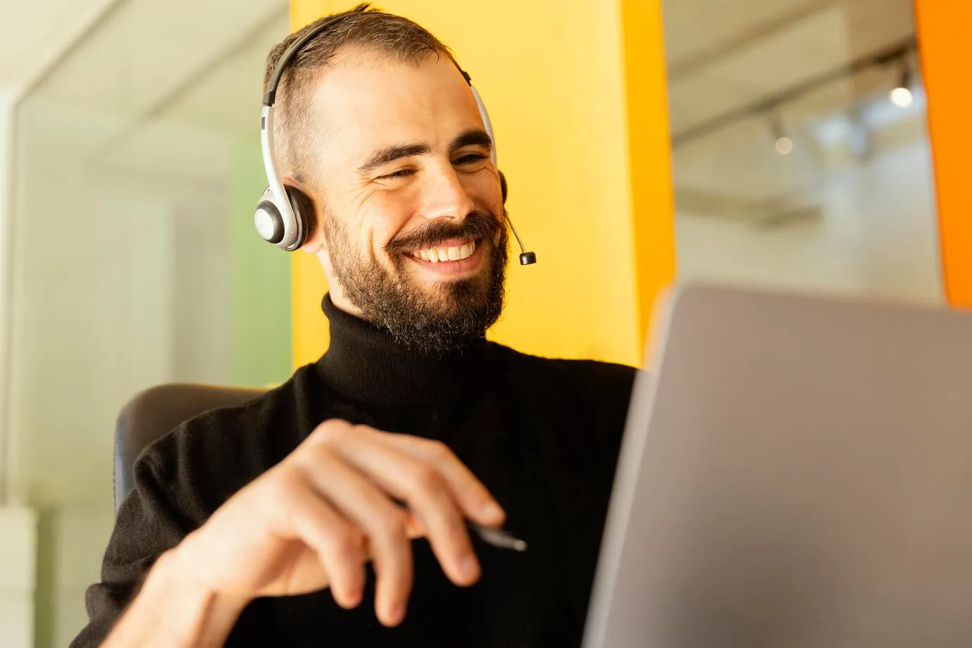 Atendente sorridente usando headset e computador, simbolizando o atendimento digital ao cidadão no portal de serviços.