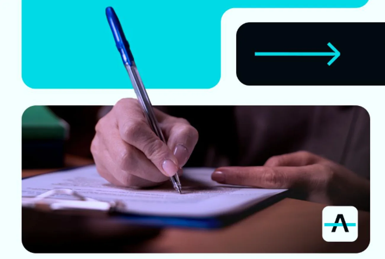 Mão assinando documento com caneta sobre uma prancheta