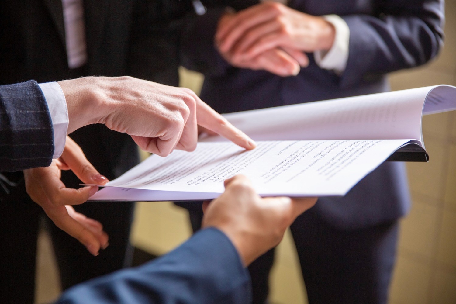 Pessoas analisando documento contratual em reunião de negócios
