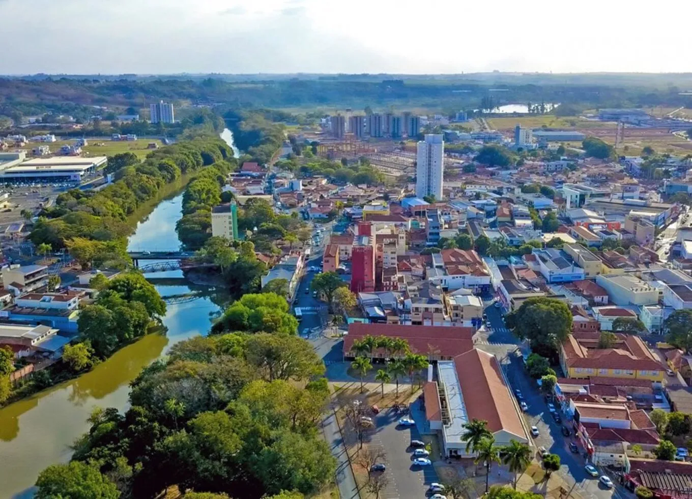 Servidores públicos sorrindo em frente a um prédio da prefeitura