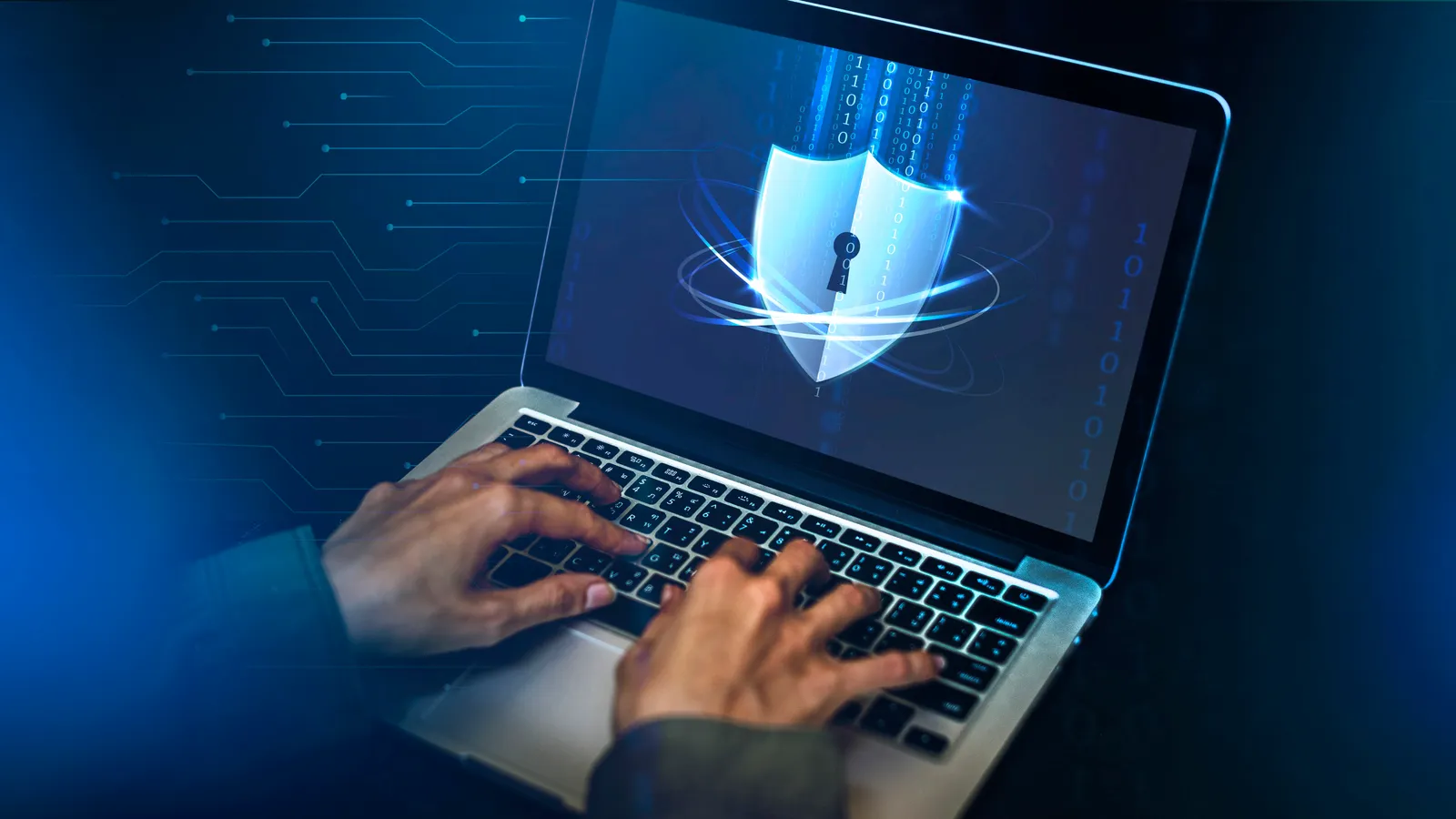 Mãos digitando em notebook com interface de sistema moderno