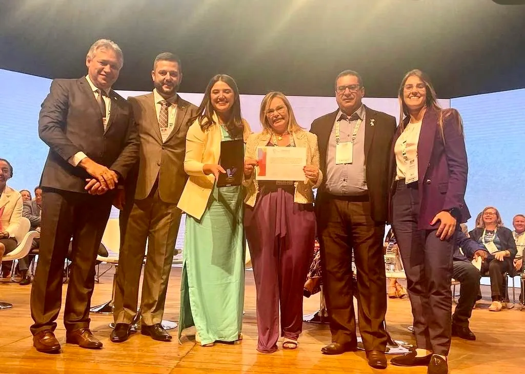 Cerimônia de premiação com autoridades e troféu de reconhecimento