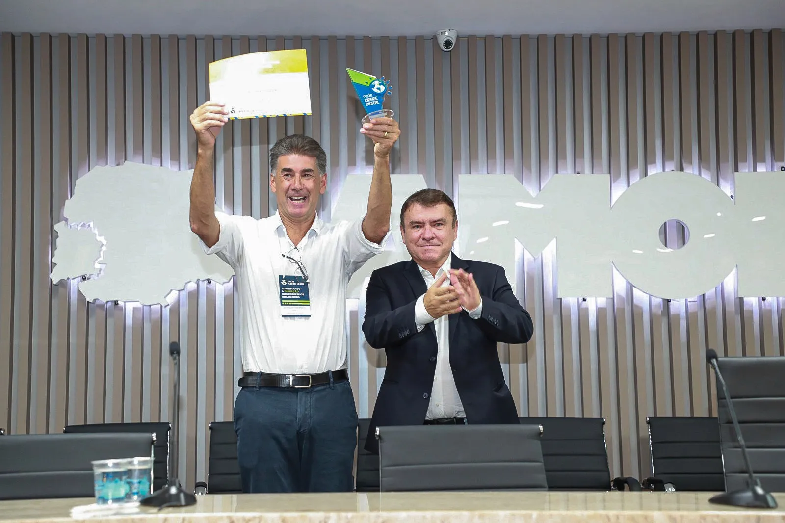 Cerimônia de premiação com autoridades e troféu de reconhecimento