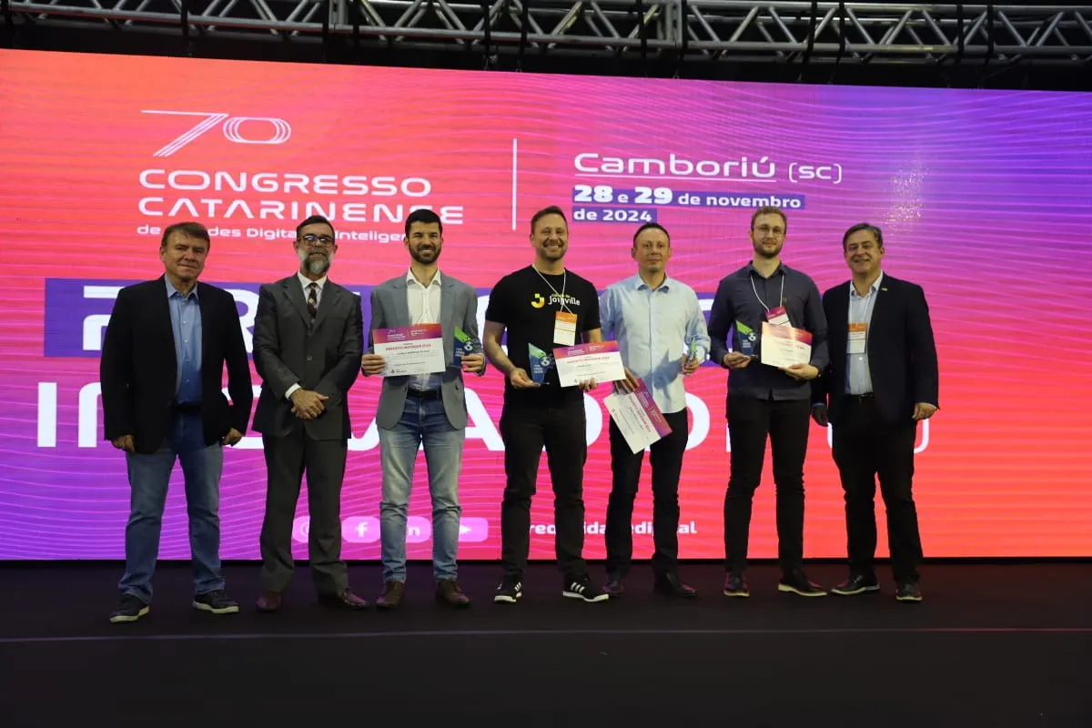 Cerimônia de premiação com autoridades e troféu de reconhecimento em Criciúma
