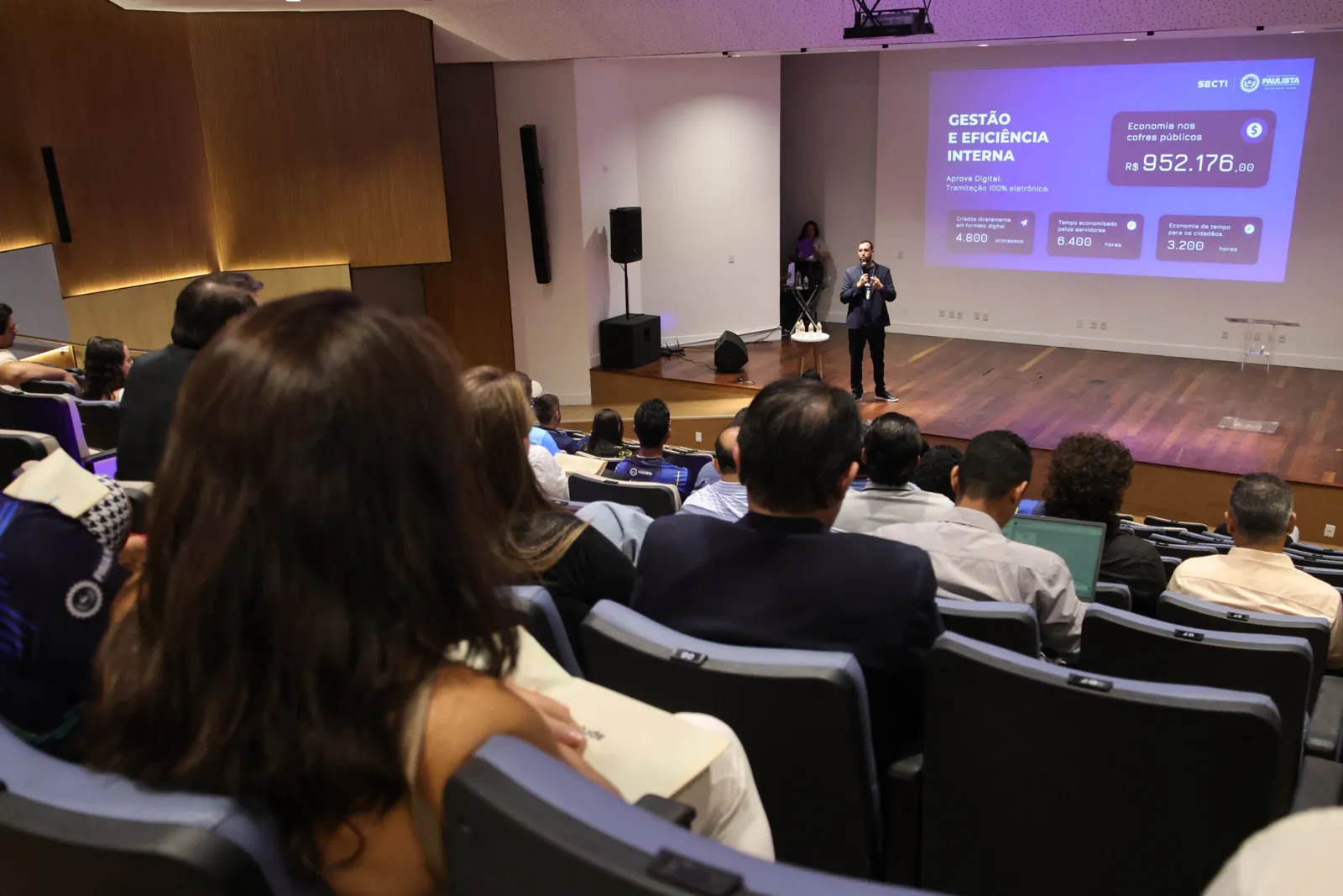 Cerimônia de premiação com autoridades e troféu de reconhecimento em Paulista